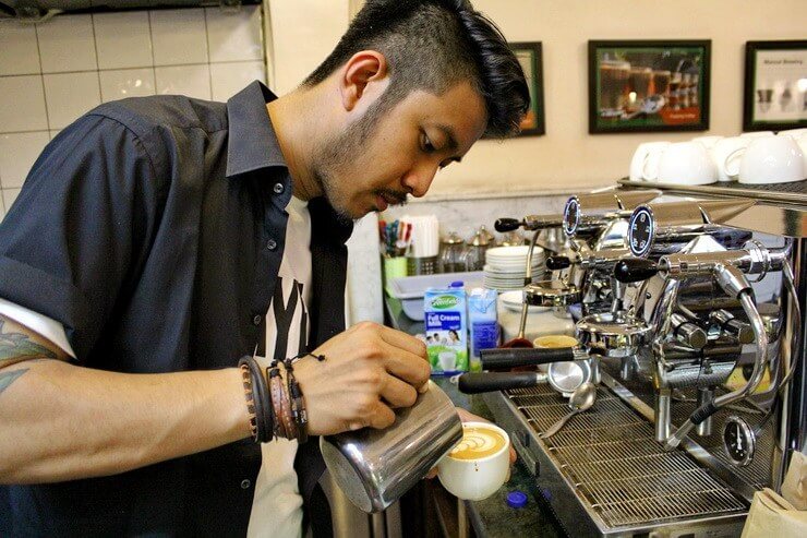 Muhammad Aga sedang melakukan latte art dengan teknik pouring